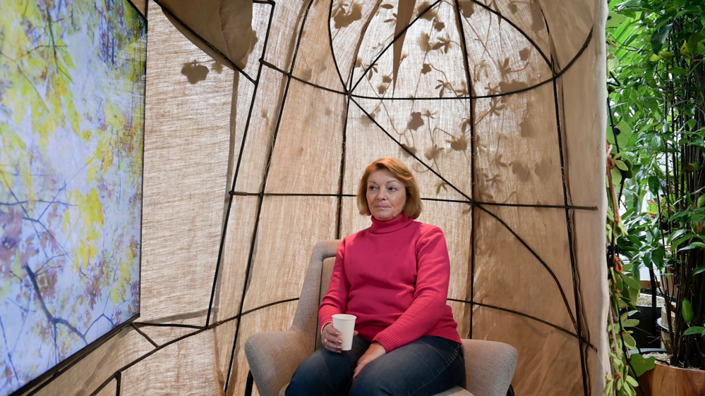 Afbeelding van een vrouw die in de groene oase zit met een drankje